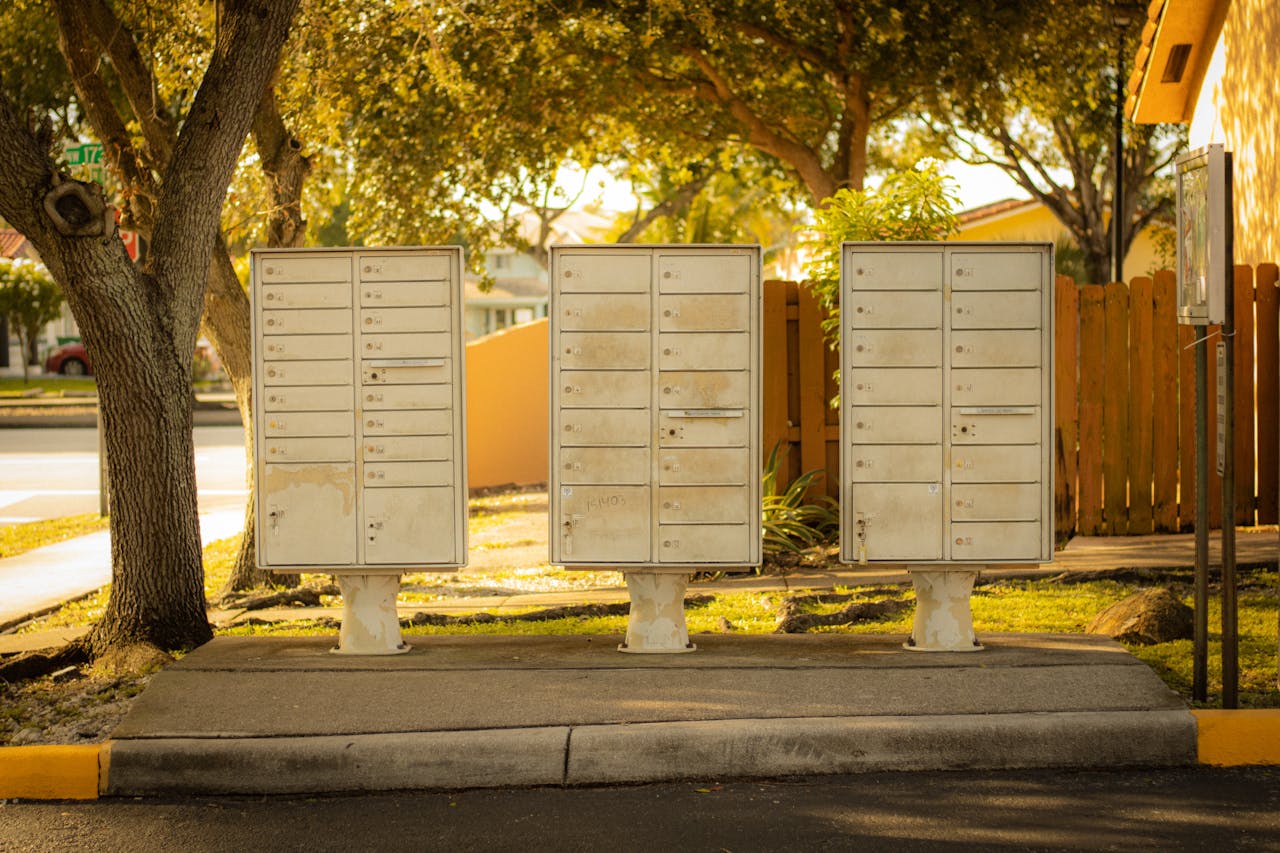 home-services-02 Three cluster mailboxes under trees in a residential area of Florida, USA, on a sunny day.